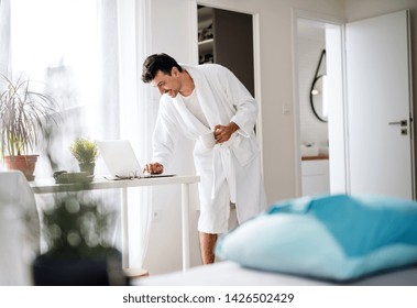 Young man with laptop and coffee in the bedroom in the morning. - Powered by Shutterstock