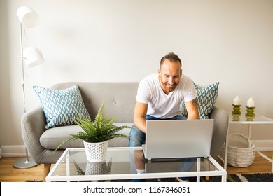 Young man with laptop computer on a comfortable couch at home - Shutterstock ID 1167346051