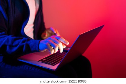 Young Man With Laptop. Red And Blue Neon Light