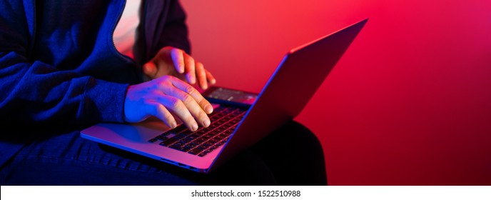 Young Man With Laptop. Red And Blue Neon Light