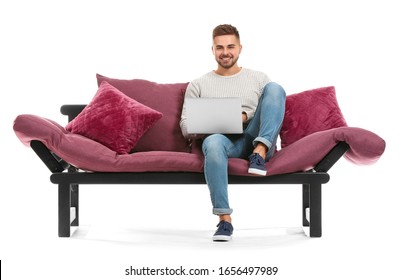 Young Man With Laptop Sitting On Sofa Against White Background