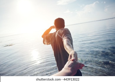 Young Man Leading By The Hand Woman Through The Water