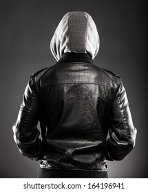 Young man in leather jacket and hood rear view on back