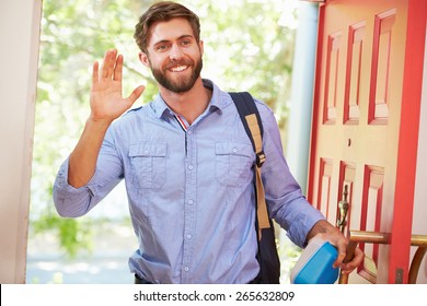 Young Man Leaving Home For Work With Packed Lunch