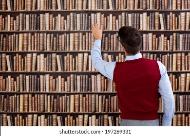 Young Man In Library Take Book From Shelf