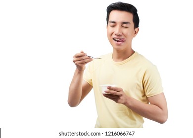 Young Man Licking Lips After Eating Yogurt, Isolated On White