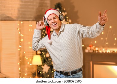 Young Man Listening To Christmas Music At Home On Christmas Eve