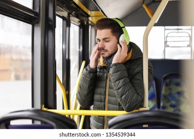 Young Man Listening To Music With Headphones In Public Transport