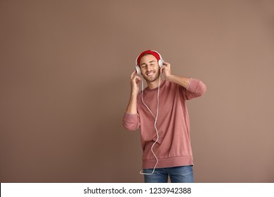 Young Man Listening To Music On Color Background