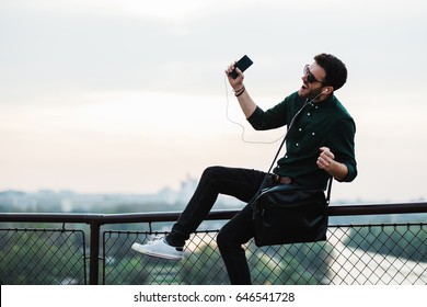 Young man listening to the music on his smartphone