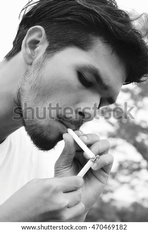 Similar – young guy in a shirt smokes on the street