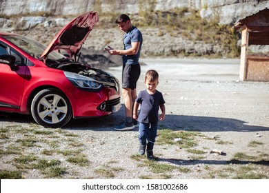 Young man and little boy together check a car. Father and son on a road with red automobile - Powered by Shutterstock