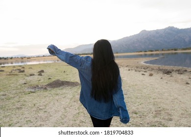 Young Man With Long Black Hair Turned From Behind In Nature