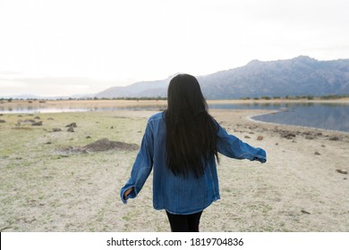 Young Man With Long Black Hair Turned From Behind In Nature