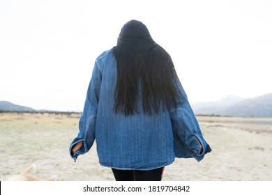 Young Man With Long Black Hair Turned From Behind In Nature