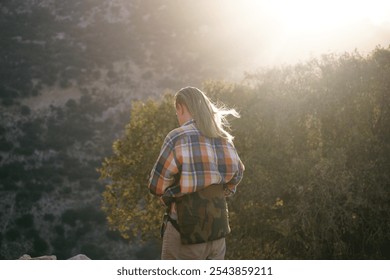 a young man with long blond hair glowing in the sun. Healthy long hair for a man - Powered by Shutterstock