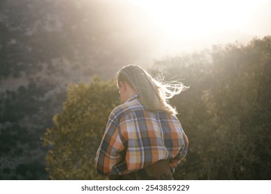 a young man with long blond hair glowing in the sun. Healthy long hair for a man - Powered by Shutterstock