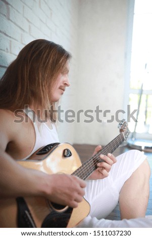 Similar – Young Boy Enjoying Music Playing Guitar Outdoors