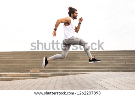 Similar – Athletic man warming up before running.