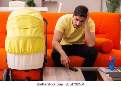 Young Man Looking After New Born At Home