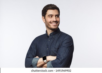 Young man looking away standing with crossed arms isolated on gray