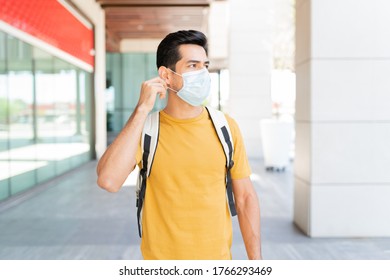 Young man looking away while wearing face mask in city during coronavirus outbreak - Powered by Shutterstock