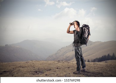 Young Man Looking With Binoculars In The Mountains