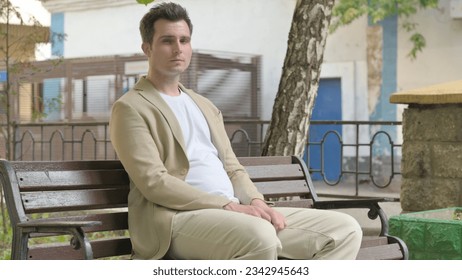 Young Man Looking at Camera while Sititng Outdoor