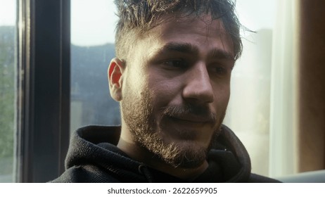 Young Man Looking Concerned While Sitting by the Window in Natural Light