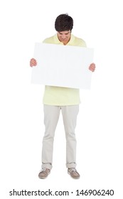 Young man looking at empty panel on a white background