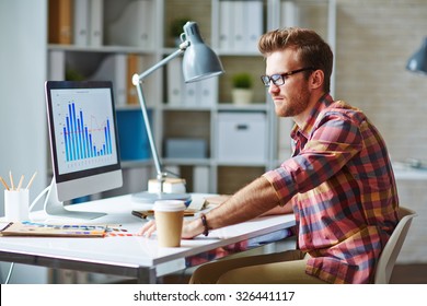 Young Man Looking At Financial Chart Reflecting Changes In Market Development