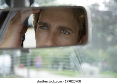 Young Man Looking Into Rear View Mirror