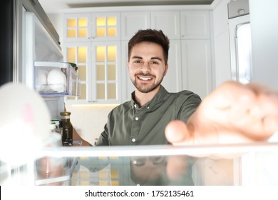 Young Man Looking Into Refrigerator, View From Inside