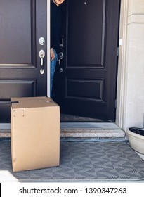 Young Man Looking At A Large Parcel Box On A Front Porch Of A House