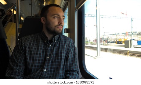 Young Man Looking Out The Window While Riding A Train.