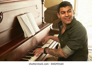 Young Man Looking Over His Shoulder Whilst Playing Piano