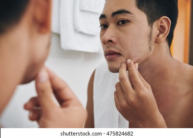 Young Man Looking At Pimple On His Chin