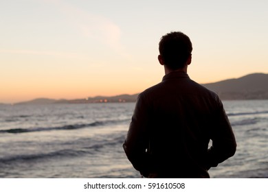 Young man looking at sea. Beach landscape. - Powered by Shutterstock