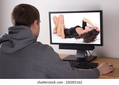 young man looking at sexy woman picture in computer