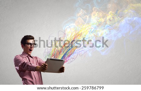 Young man looking with shock in tablet pc