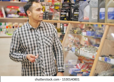 Young Man Looking At Shop Window In Auto Parts Store