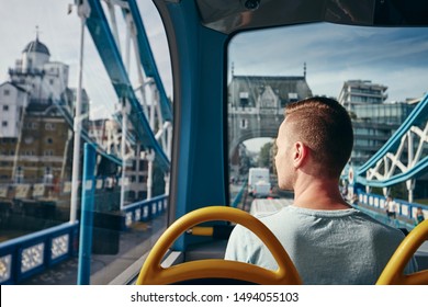 Young Man Looking Through Window From Double Decker Bus. City Life In London, United Kingdom.