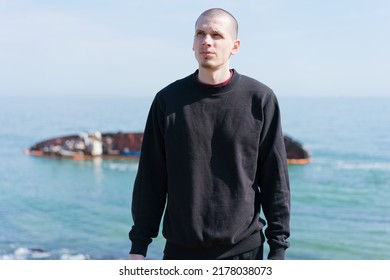 A Young Man Looks Up Near The Sea, With A Sunken Ship In The Background. Adult. Water. Beach. Summer. Confident. Guy. Masculine. Mid Adult. Model. Outside. Stylish. Looking