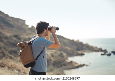 Young Man Looks For A Target With Binoculars