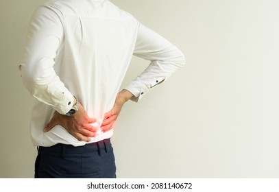 A Young Man With Lumbago From Work, Focusing On Red Spots On White Background.