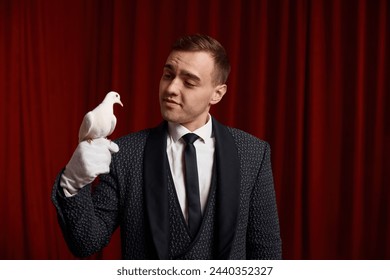 Young man magician showing trick with white dove bird selective focus - Powered by Shutterstock