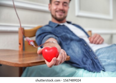 Young Man Making Blood Donation In Hospital, Focus On Hand