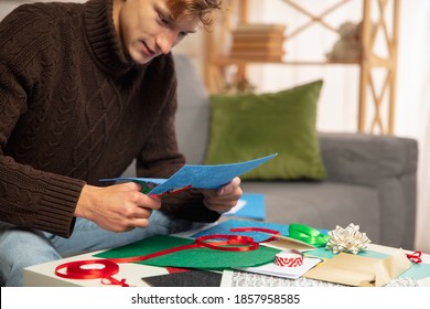 Young Man Making Greeting Card For New Year And Christmas 2021 For Friends Or Family, Scrap Booking, DIY. Writing A Letter With Best Wishes, Design His Homemade Card. Holidays, Celebration.