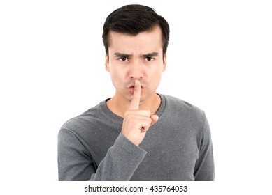 Young man making hush (shh) gesture - quiet or secret sign