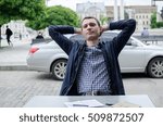 Young man making notes in the notepad on the street